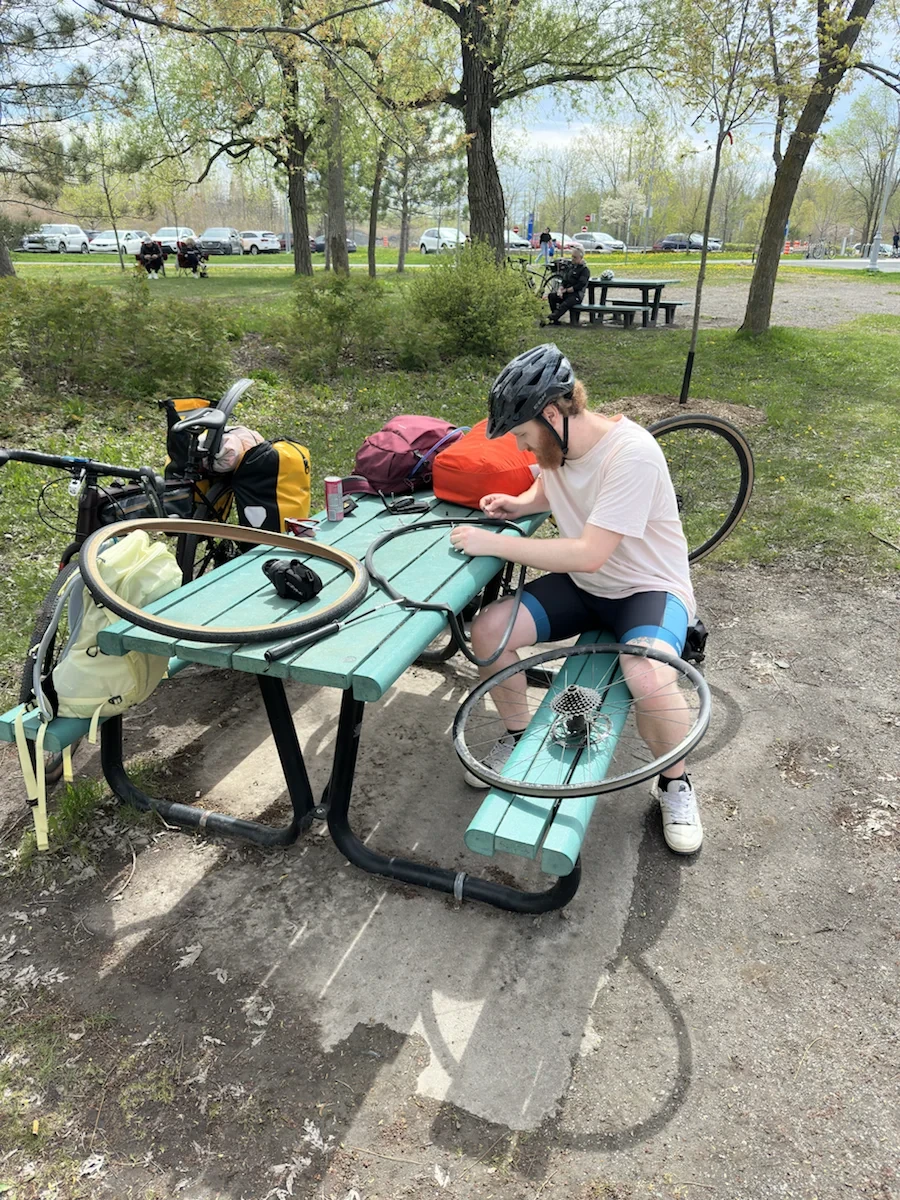 Fixing a bicycle at a picnic table during a ride