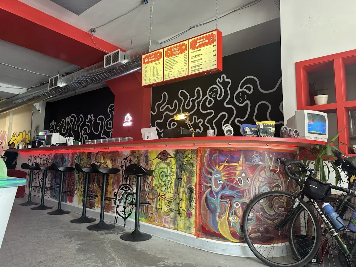 A loaded bicycle inside a colourful arcade café